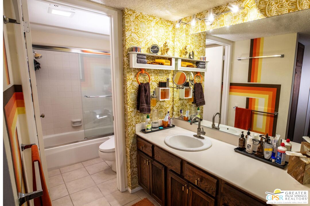 1050 Ramon Road, Unit 34 Palm Springs, CA 92264 - Photo 3 of 10 a bathroom with a sink a toilet a mirror and shower