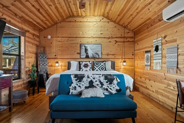 a bedroom with furniture large window and flat screen tv