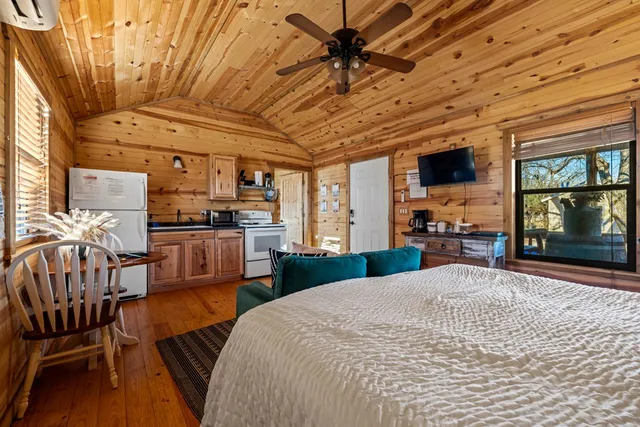 a kitchen with stainless steel appliances a stove a sink refrigerator and a dining table with wooden floors