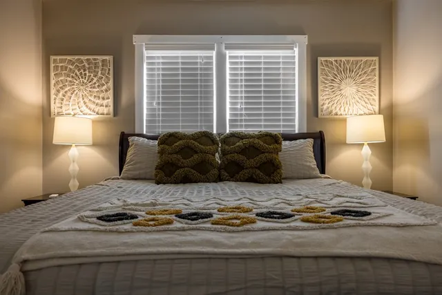 a bedroom with a bed and a lamp with window