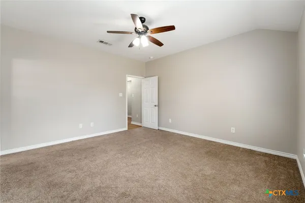 an empty room with closet and ceiling fan