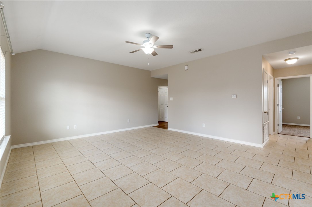 916 Freedom Drive Temple, TX 76502 - Photo 7 of 24 an empty room with white walls and chandelier fan