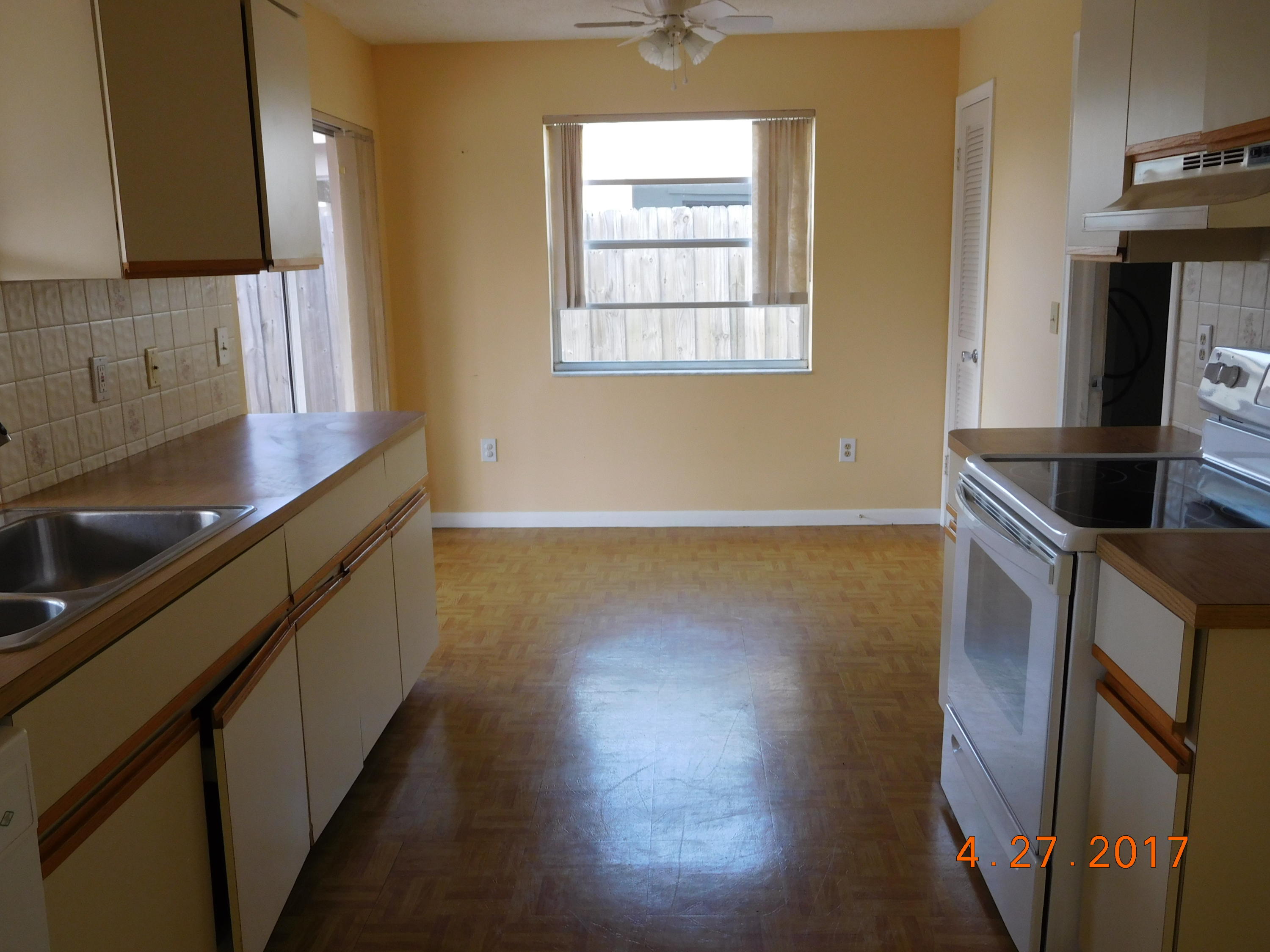 22367 Southwest 65th Avenue Boca Raton, FL 33428 - Photo 7 of 13 a kitchen with granite countertop a sink a stove and a wooden floor