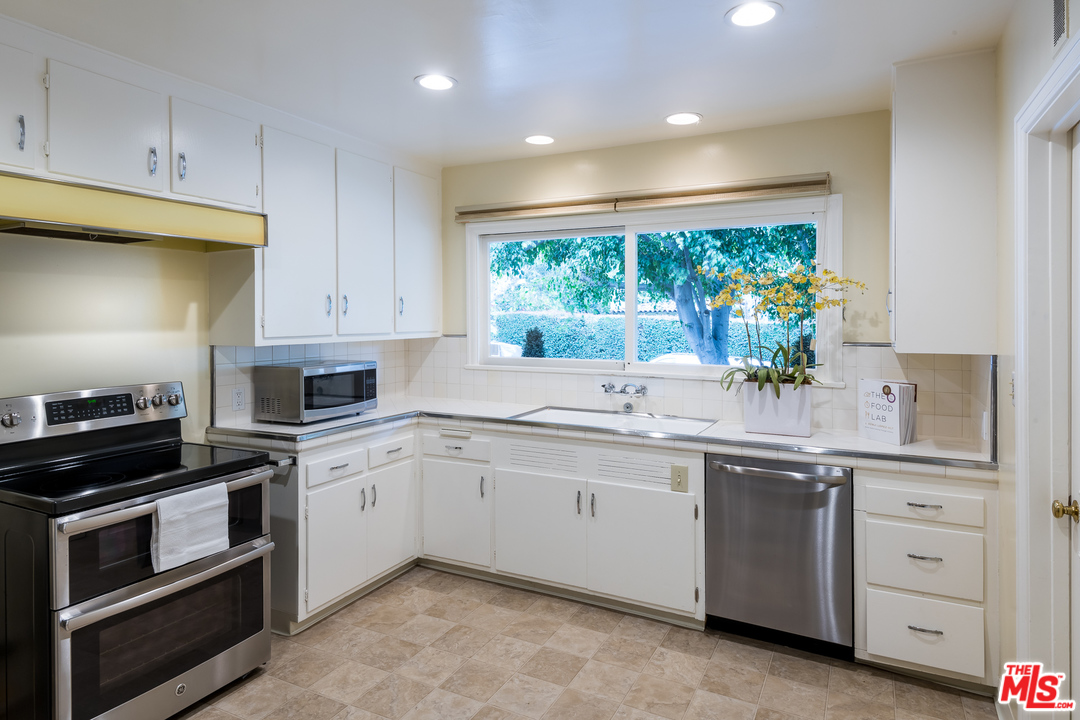 10886 Chalon Road Los Angeles, CA 90077 - Photo 12 of 33 a kitchen with a sink stove and cabinets