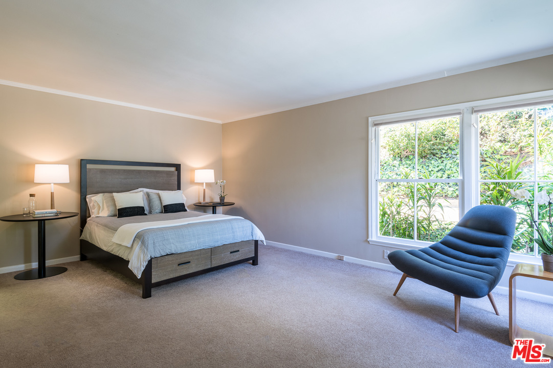 10886 Chalon Road Los Angeles, CA 90077 - Photo 15 of 33 a bedroom with a bed chair and a window