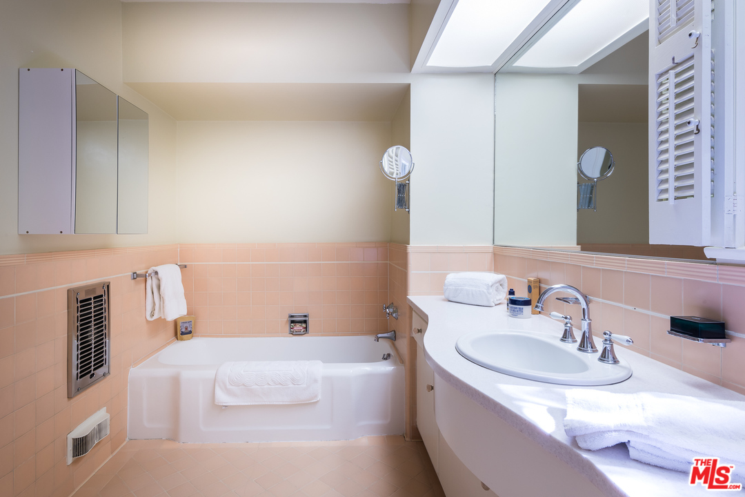 10886 Chalon Road Los Angeles, CA 90077 - Photo 18 of 33 a bathroom with a tub sink and mirror