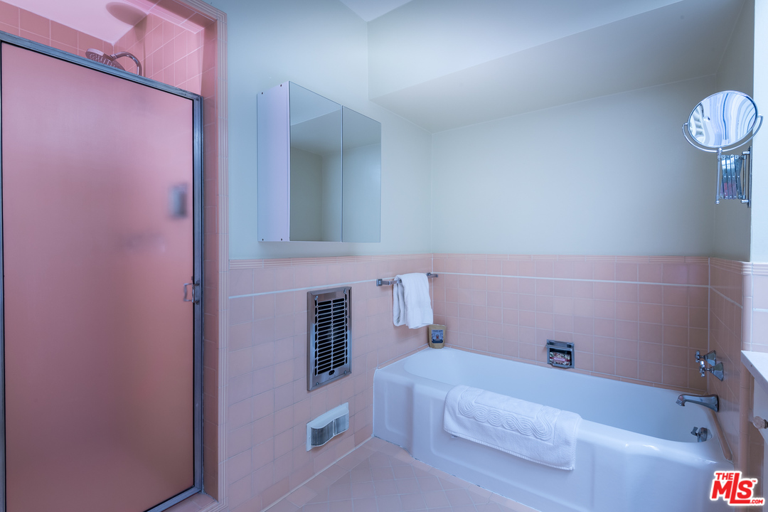 10886 Chalon Road Los Angeles, CA 90077 - Photo 19 of 33 a bathroom with a sink and bathtub with shower