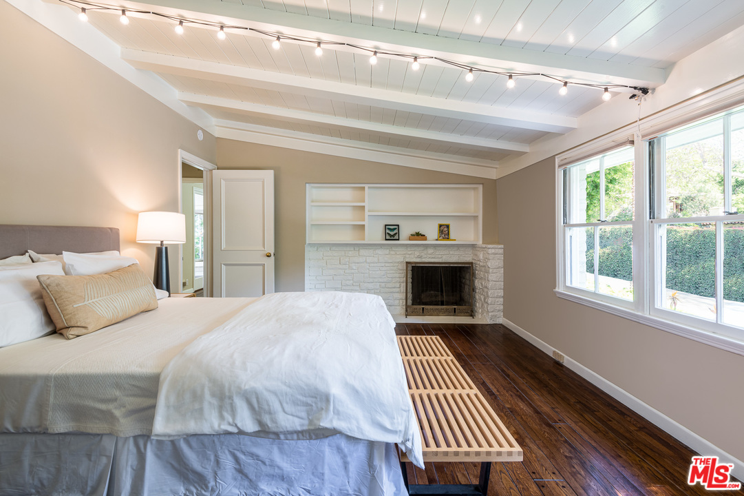 10886 Chalon Road Los Angeles, CA 90077 - Photo 21 of 33 a spacious bedroom with a bed and wooden floor