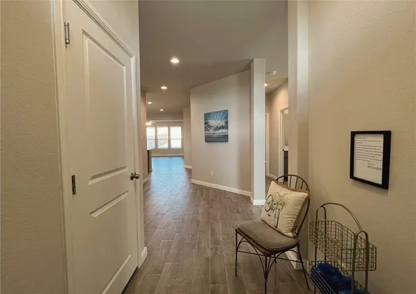 a view of a hallway with wooden floor and furniture
