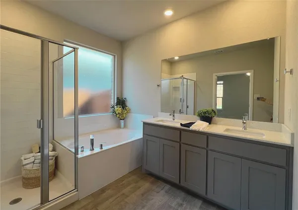 a bathroom with a double vanity sink mirror and bathtub