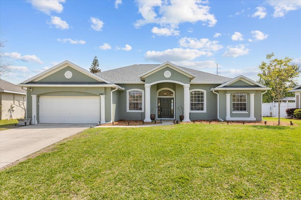 2309 Wolf Ridge Lane Mount Dora, FL 32757 - Photo 1 of 36 a front view of a house with a garden and yard