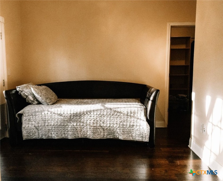 447 Schaefer Road Victoria, TX 77905 - Photo 20 of 25 a bed sitting in a bedroom next to a window with wooden floor