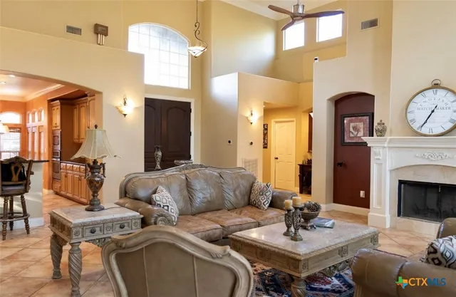a living room with furniture a fireplace and a chandelier
