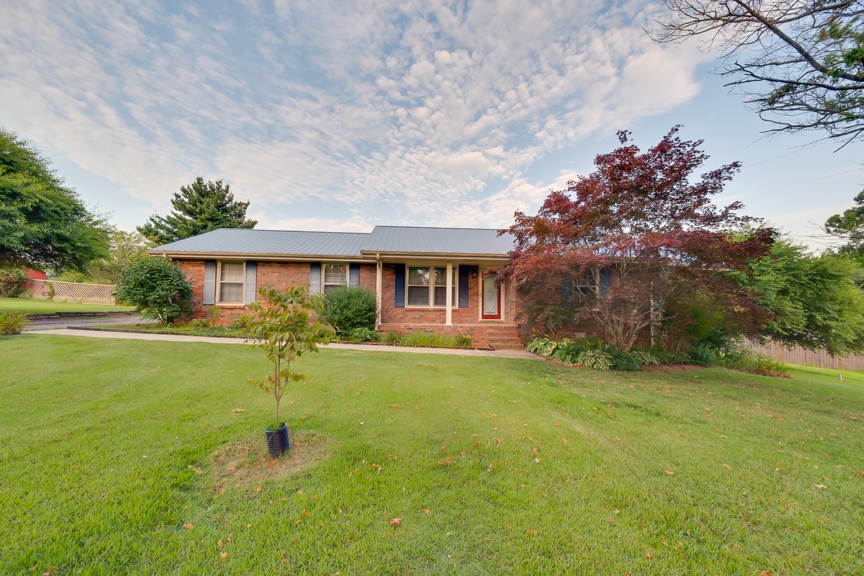 116 Green Acres Road Cottontown, TN 37048 - Photo 6 of 44 a front view of a house with a garden and trees