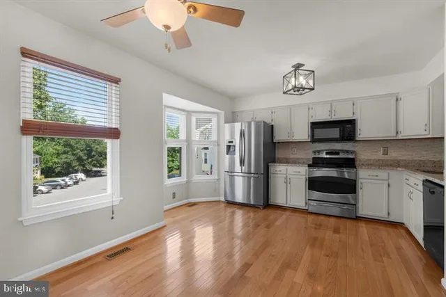 a kitchen with stainless steel appliances a stove a refrigerator and a microwave