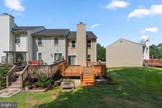 a view of a house with a backyard and a tree