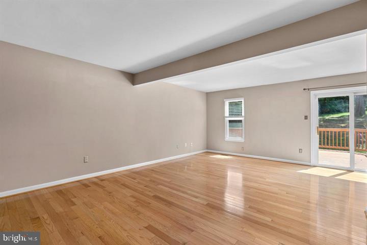 1163 Kelfield Drive, Unit 1163 Baltimore, MD 21227 - Photo 4 of 28 a view of an empty room with wooden floor and a window