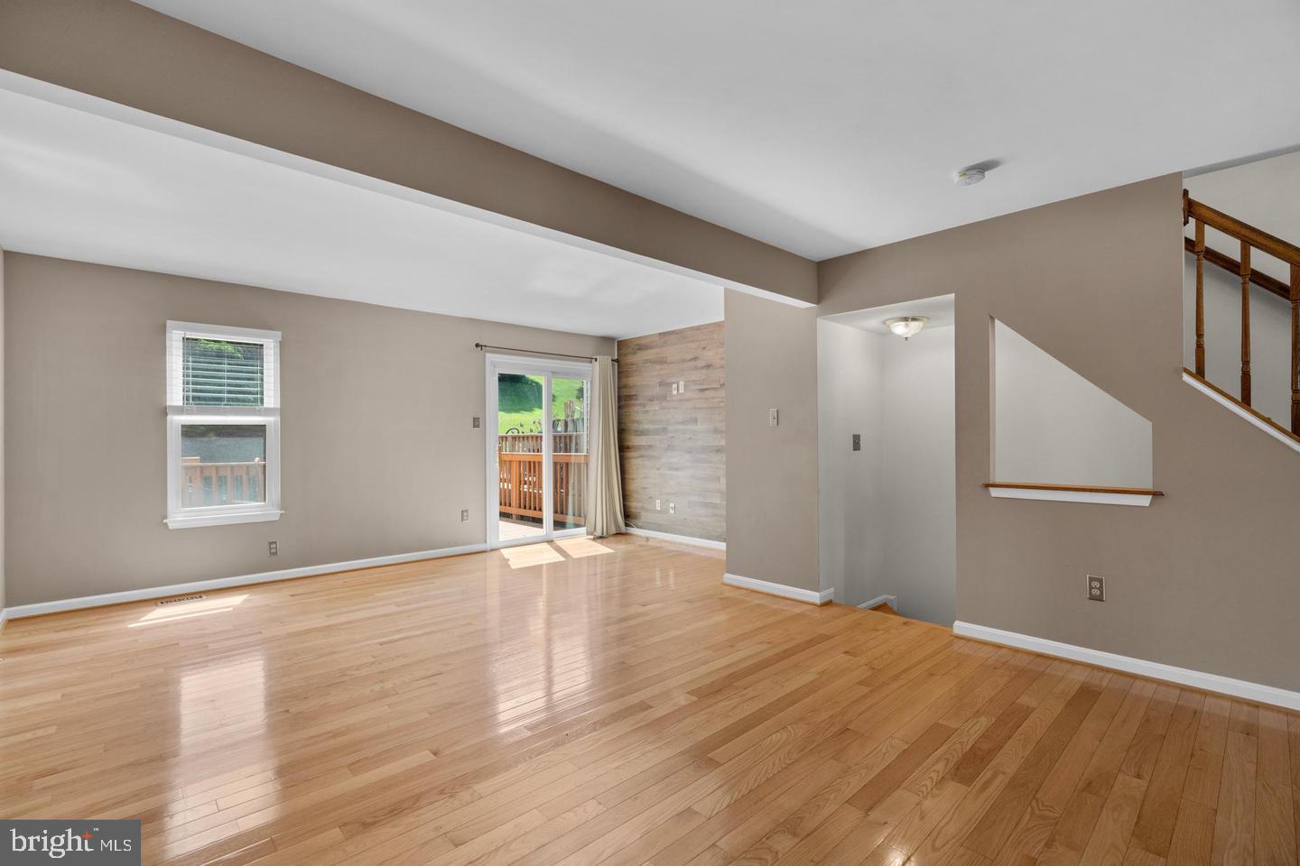 1163 Kelfield Drive, Unit 1163 Baltimore, MD 21227 - Photo 6 of 28 a view of an empty room with wooden floor and a window