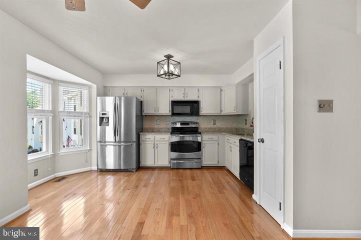 1163 Kelfield Drive, Unit 1163 Baltimore, MD 21227 - Photo 7 of 28 a kitchen with stainless steel appliances a refrigerator and a stove top oven