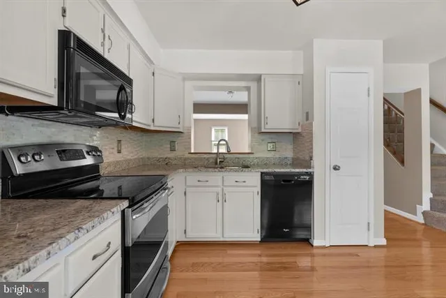 a kitchen with stainless steel appliances granite countertop a stove a sink and a microwave