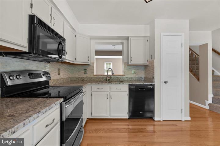 1163 Kelfield Drive, Unit 1163 Baltimore, MD 21227 - Photo 9 of 28 a kitchen with stainless steel appliances granite countertop a stove a sink and a microwave
