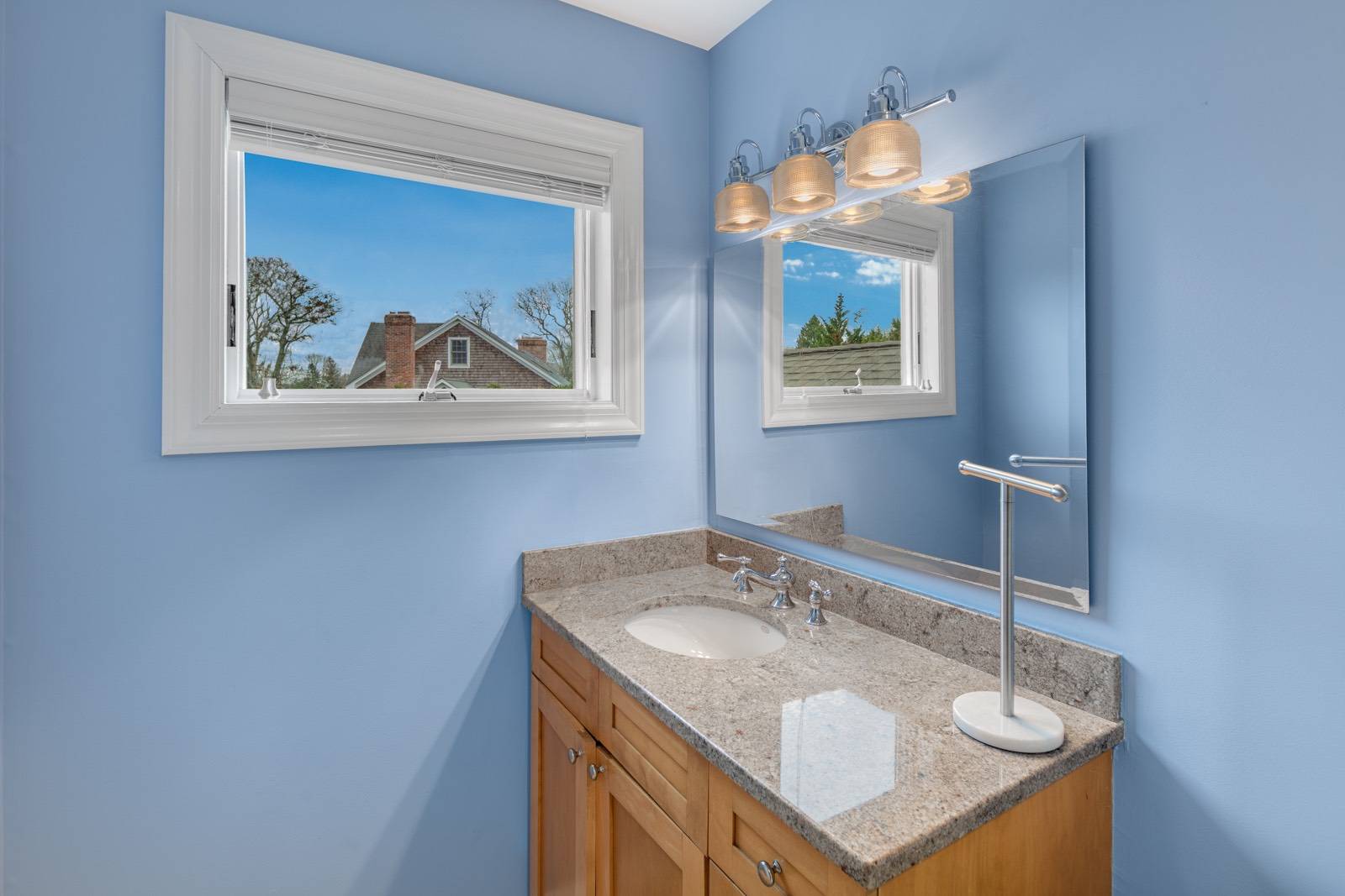 32 A Vail Avenue East Quogue, NY 11942 - Photo 17 of 24 a bathroom with a sink a mirror and a painting on the wall