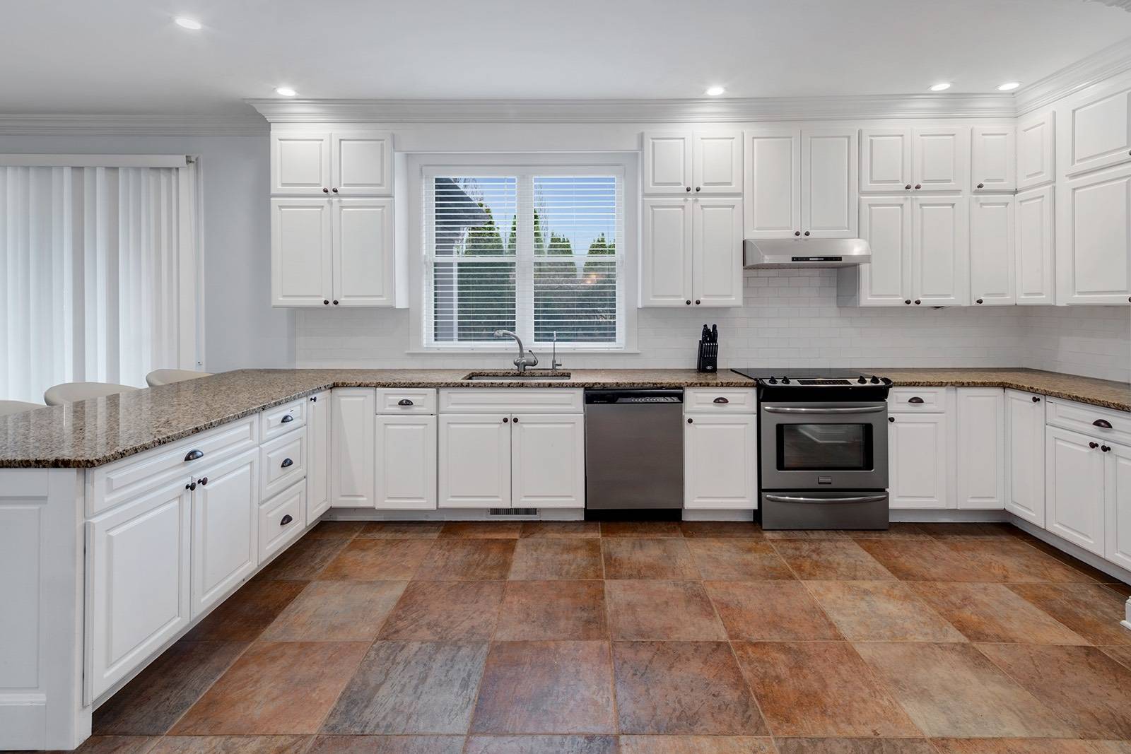 32 A Vail Avenue East Quogue, NY 11942 - Photo 6 of 24 a large kitchen with cabinets and stainless steel appliances