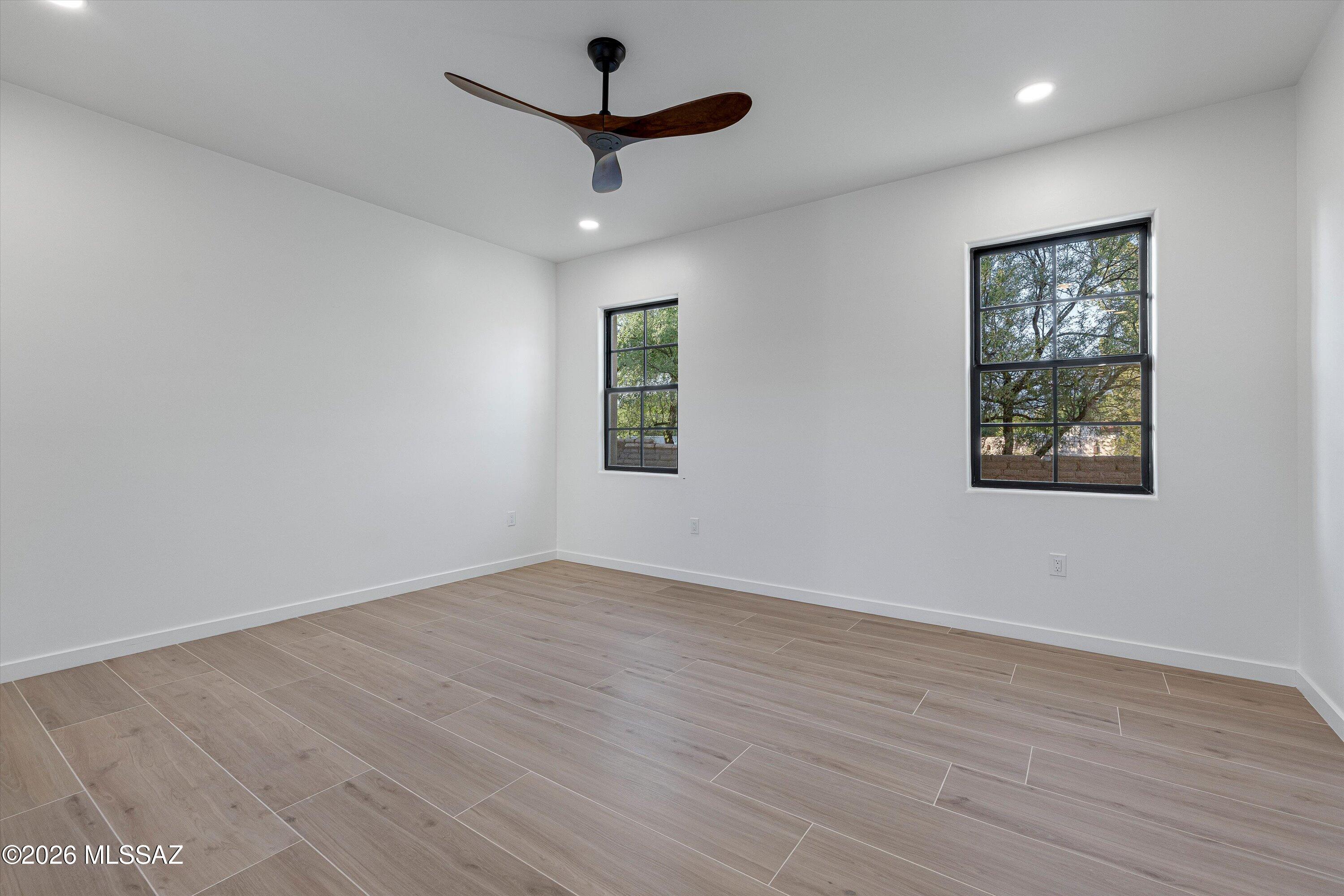 5259 East Fort Lowell Road Tucson, AZ 85712 - Photo 22 of 50 a view of an empty room with wooden floor and a ceiling fan