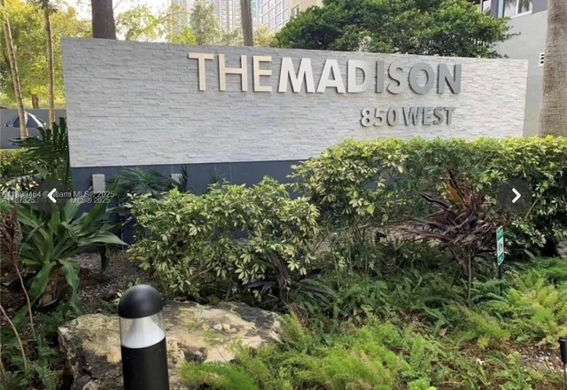 a view of sign board with potted plants