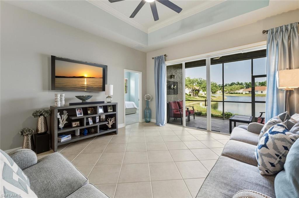 8063 Sanctuary Drive, Unit 1 Naples, FL 34104 - Photo 11 of 30 Living area with a raised ceiling, light tile patterned floors, crown molding, and ceiling fan