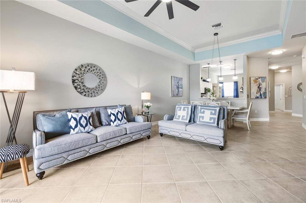 8063 Sanctuary Drive, Unit 1 Naples, FL 34104 - Photo 12 of 30 Living room featuring ornamental molding, light tile patterned floors, a raised ceiling, and ceiling fan