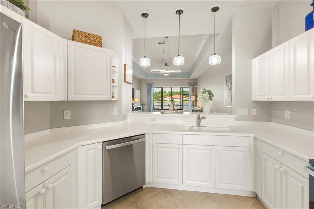 8063 Sanctuary Drive, Unit 1 Naples, FL 34104 - Photo 18 of 30 Kitchen with a raised ceiling, white cabinetry, and ornamental molding