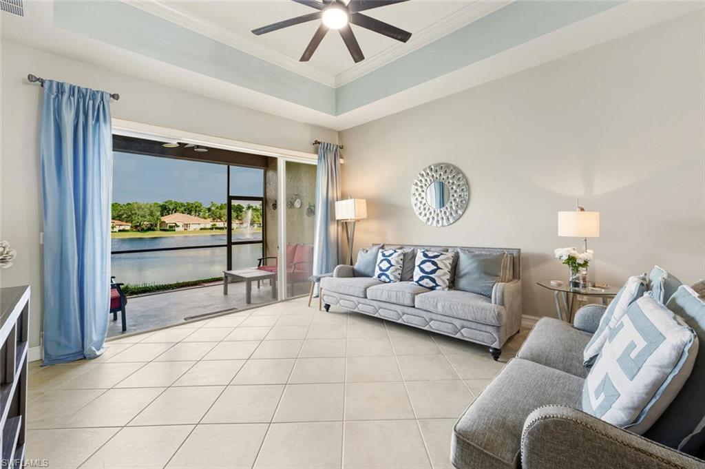 8063 Sanctuary Drive, Unit 1 Naples, FL 34104 - Photo 10 of 30 Living area with a water view, a raised ceiling, light tile patterned floors, a ceiling fan, and ornamental molding