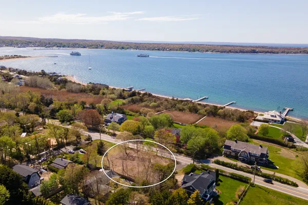 an aerial view of ocean and residential houses with outdoor space
