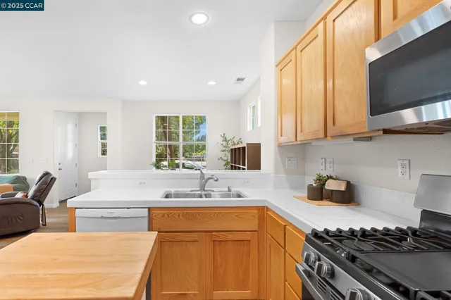 a kitchen with stainless steel appliances sink stove and white cabinets