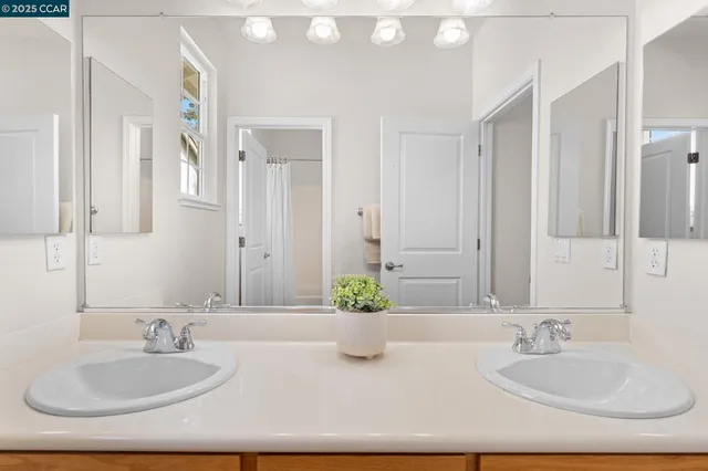 a bathroom with a granite countertop sink a mirror and a bathtub