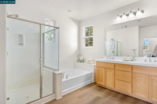 a spacious bathroom with a tub sink and mirror