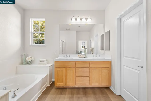 a bathroom with a tub a sink and a mirror