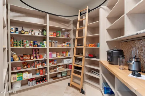 a kitchen with stainless steel appliances granite countertop a sink a stove a refrigerator and island with wooden cabinets