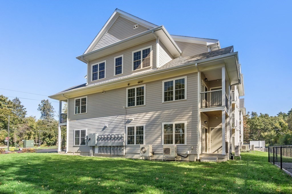 242 Main Street, Unit 206 Millis, MA 02054 - Photo 3 of 18 a front view of a house with a garden and plants
