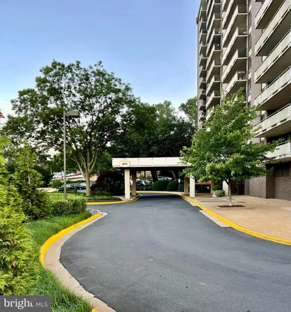 a view of swimming pool with outdoor seating and trees in the background