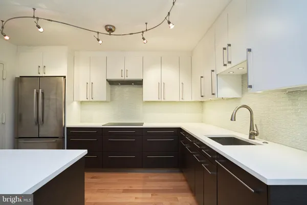 a kitchen with a sink a refrigerator and cabinets