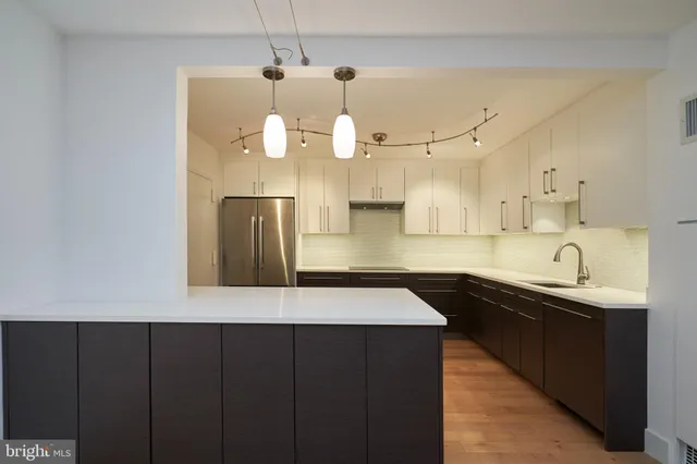a kitchen with a sink a counter space and cabinets