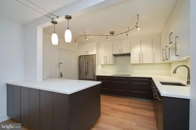 a kitchen with a refrigerator a sink and cabinets