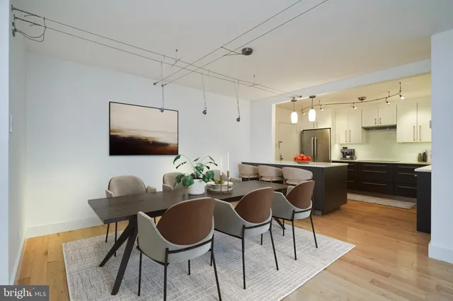 a kitchen with stainless steel appliances kitchen island granite countertop a dining table chairs and sink