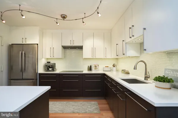 a kitchen with a sink a refrigerator and cabinets