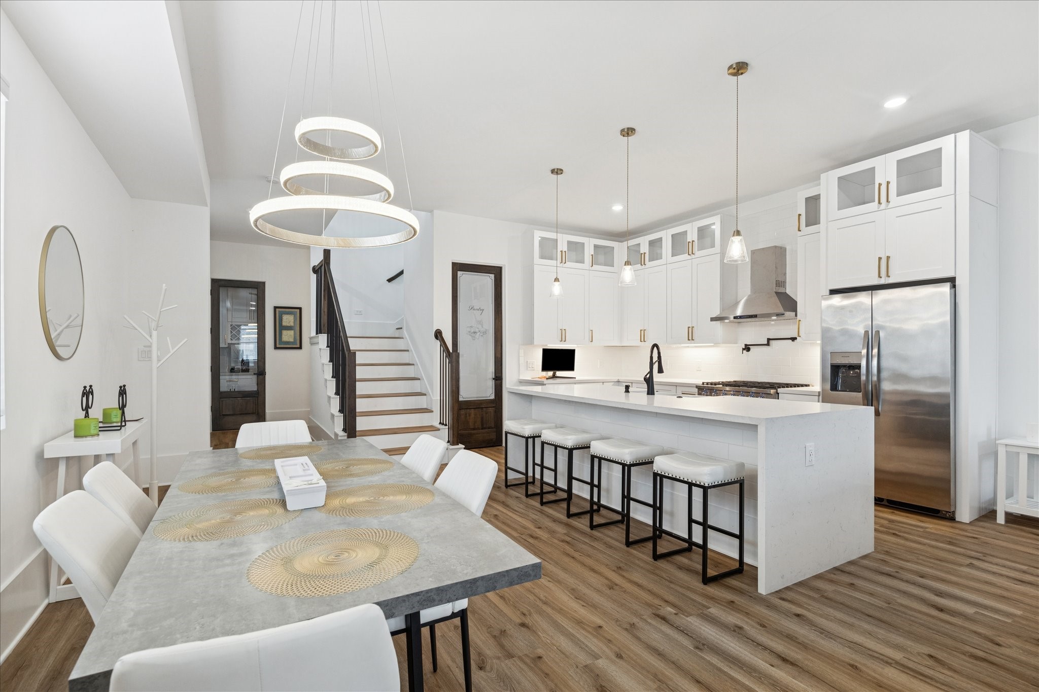 9233 Madera Road Houston, TX 77078 - Photo 8 of 25 a large kitchen with kitchen island a refrigerator a stove a sink a dining table and chairs with wooden floor