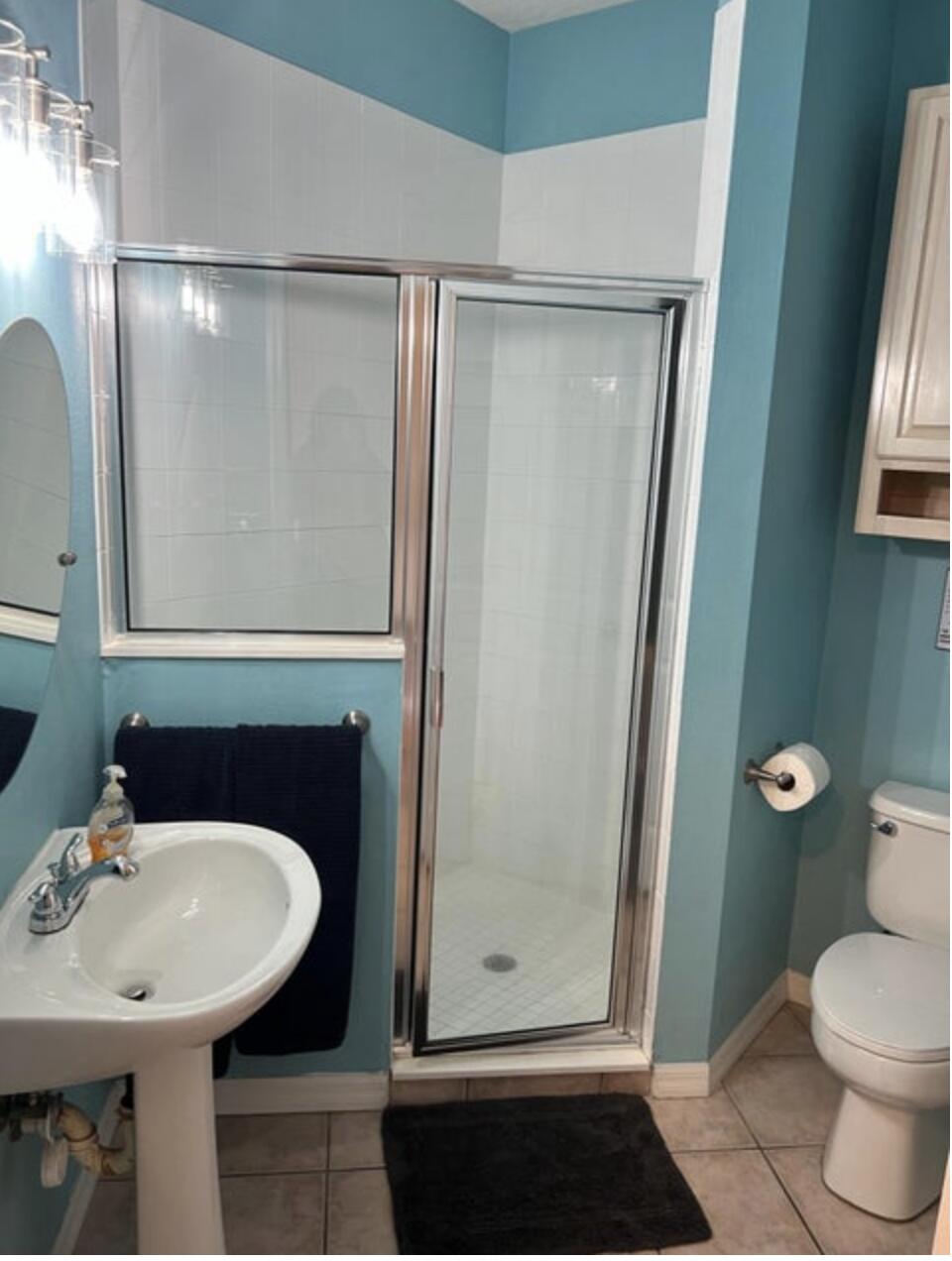 9871 Perfect Drive, Unit 144 Port St. Lucie, FL 34986 - Photo 3 of 11 a bathroom with a sink a toilet a mirror and shower
