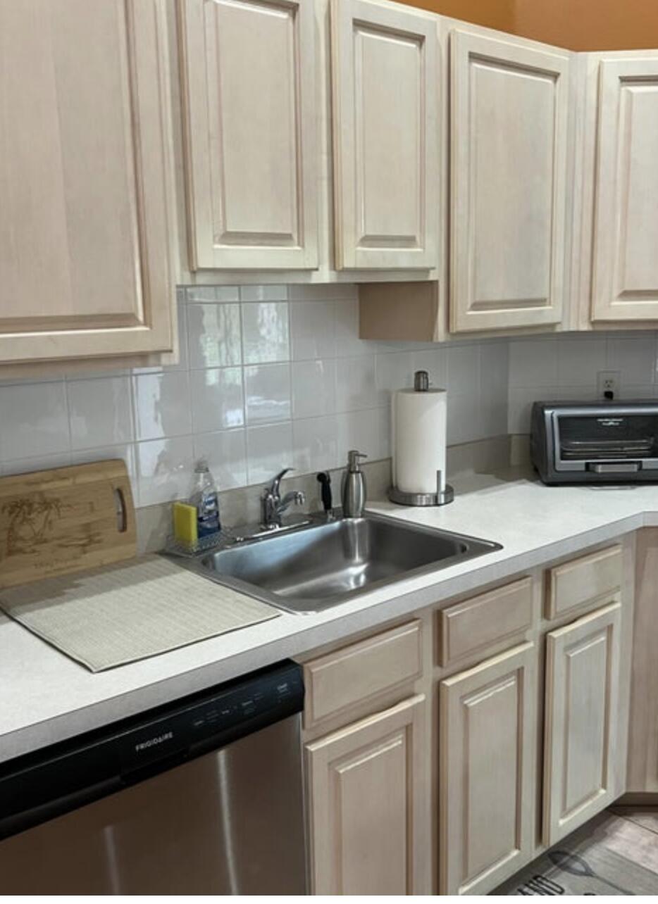 9871 Perfect Drive, Unit 144 Port St. Lucie, FL 34986 - Photo 5 of 11 a kitchen with white cabinets and a sink
