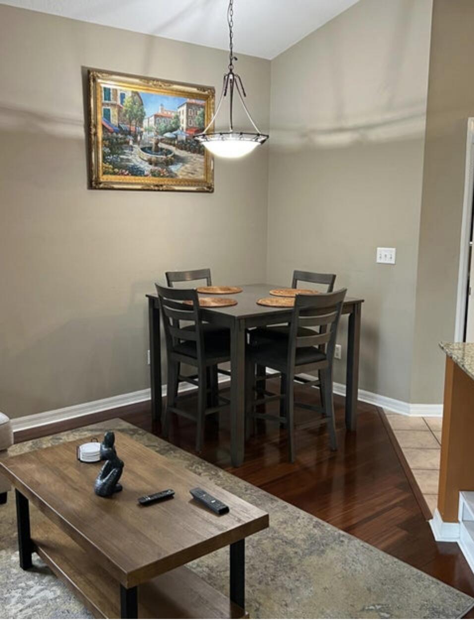 9871 Perfect Drive, Unit 144 Port St. Lucie, FL 34986 - Photo 6 of 11 a view of a dining room with furniture wooden floor and chandelier